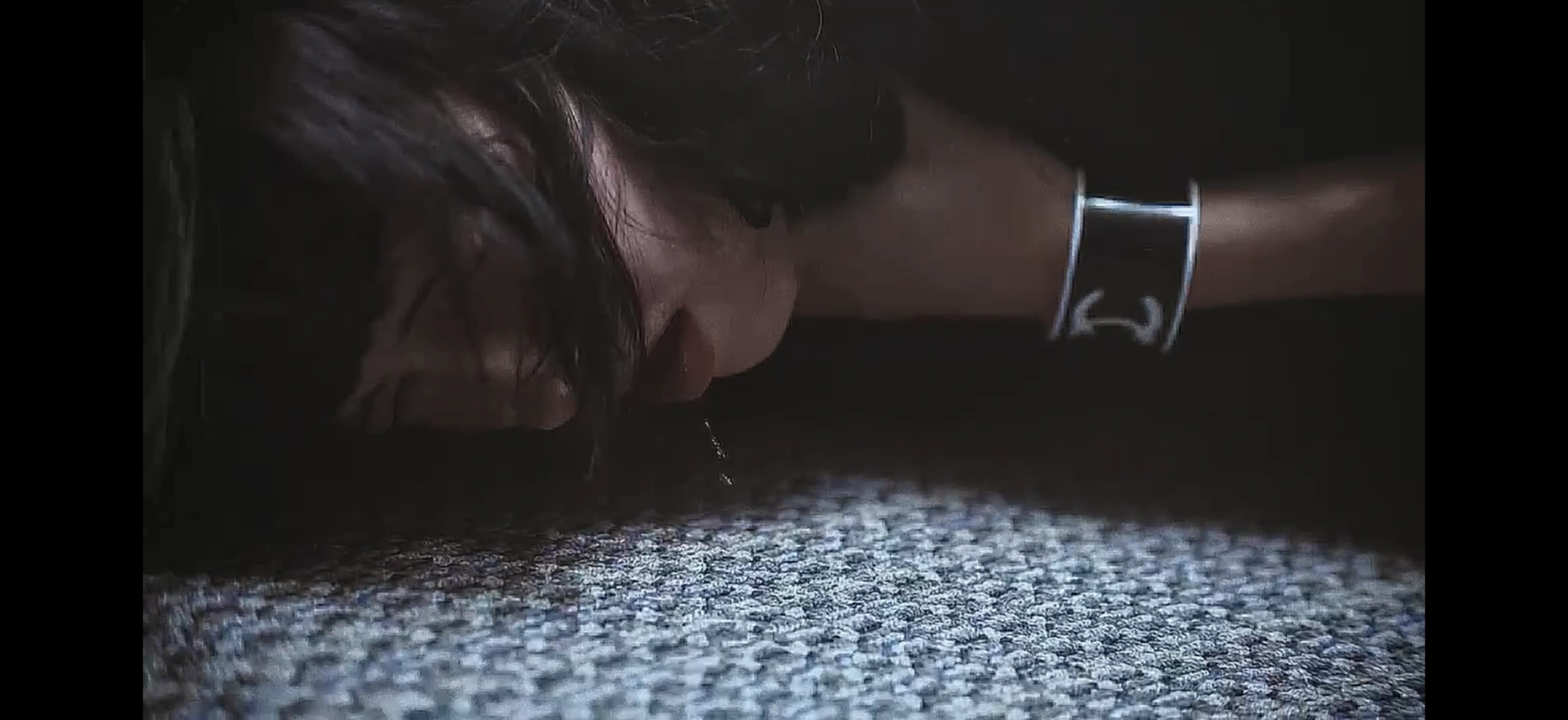A close-up of a figure lying against a carpet