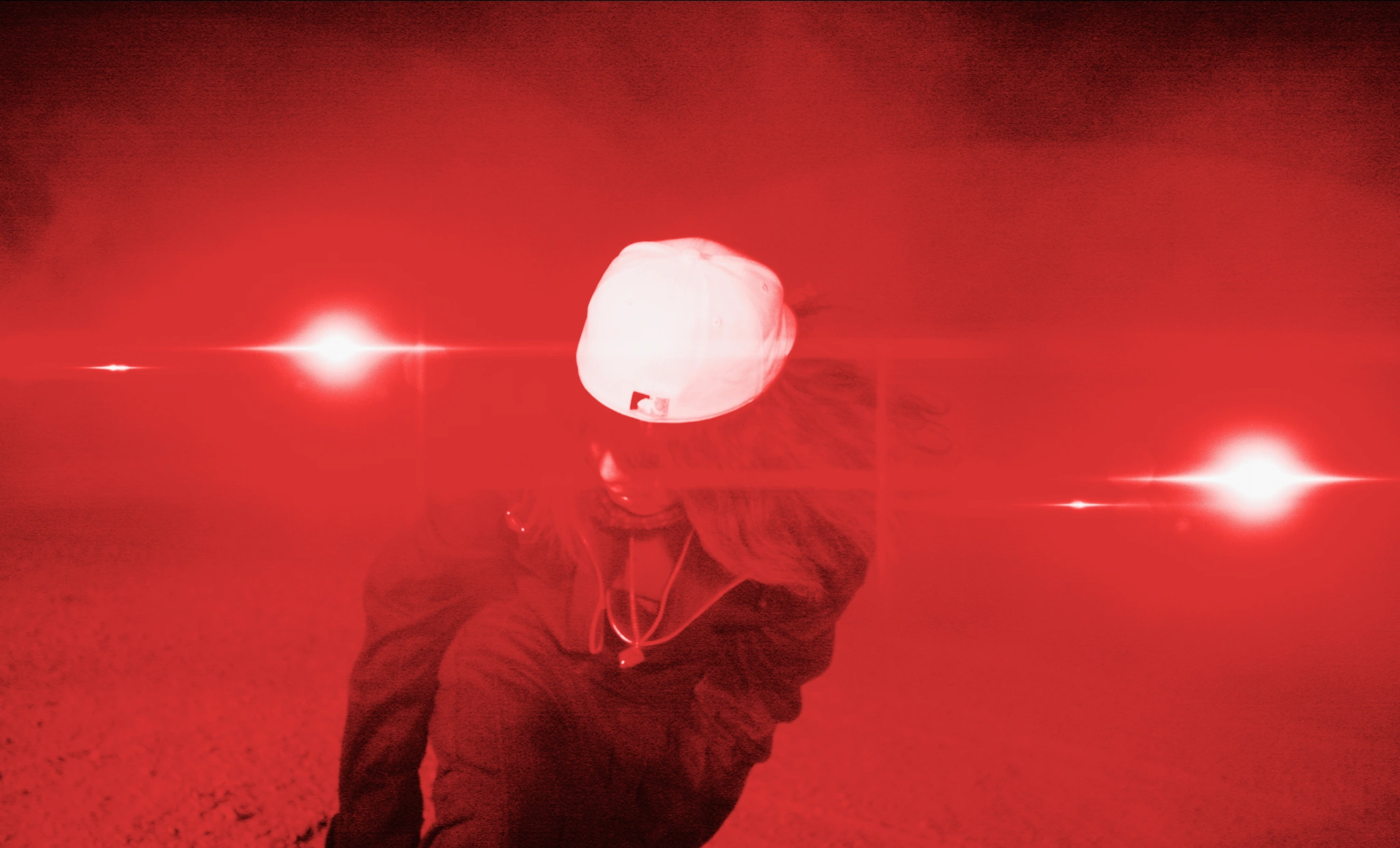 A figure surrounded by red haze and lights